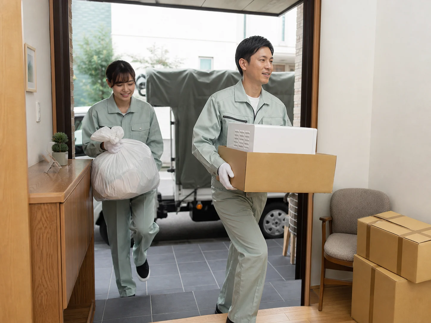 仕分けを終えた不用品を住宅から搬出するスタッフ