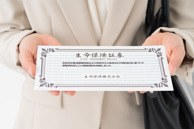 生命保険証券を持つ女性