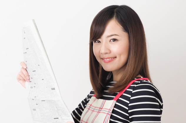 新聞紙を持つ主婦