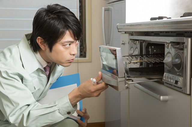 ガスコンロをチェックする男性