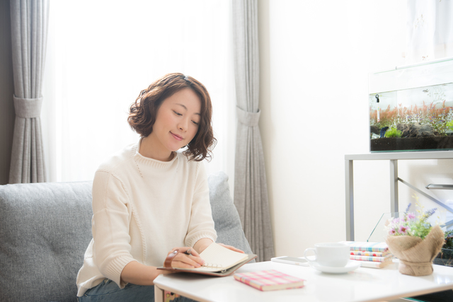 手帳に書き込む主婦