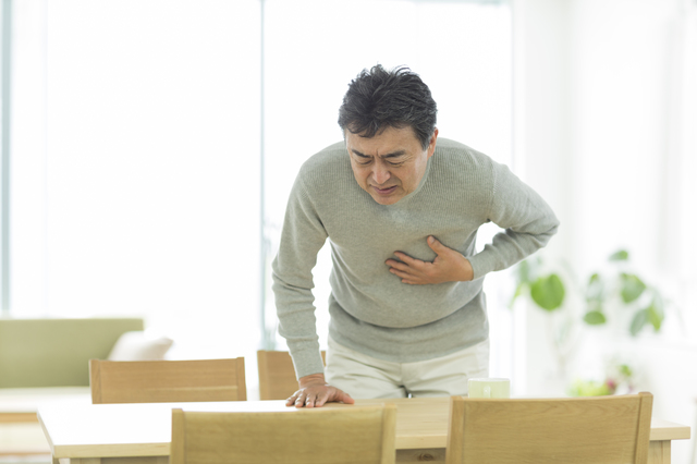 心臓をおさえる男性