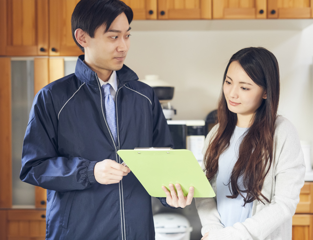 見積もりをする業者と女性