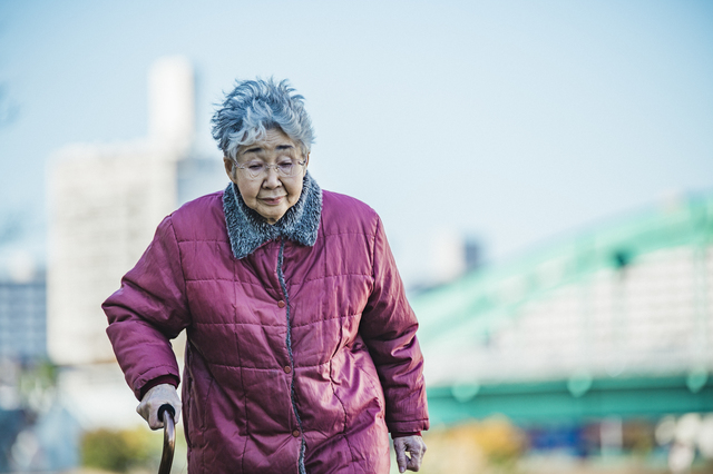 杖をつく女性
